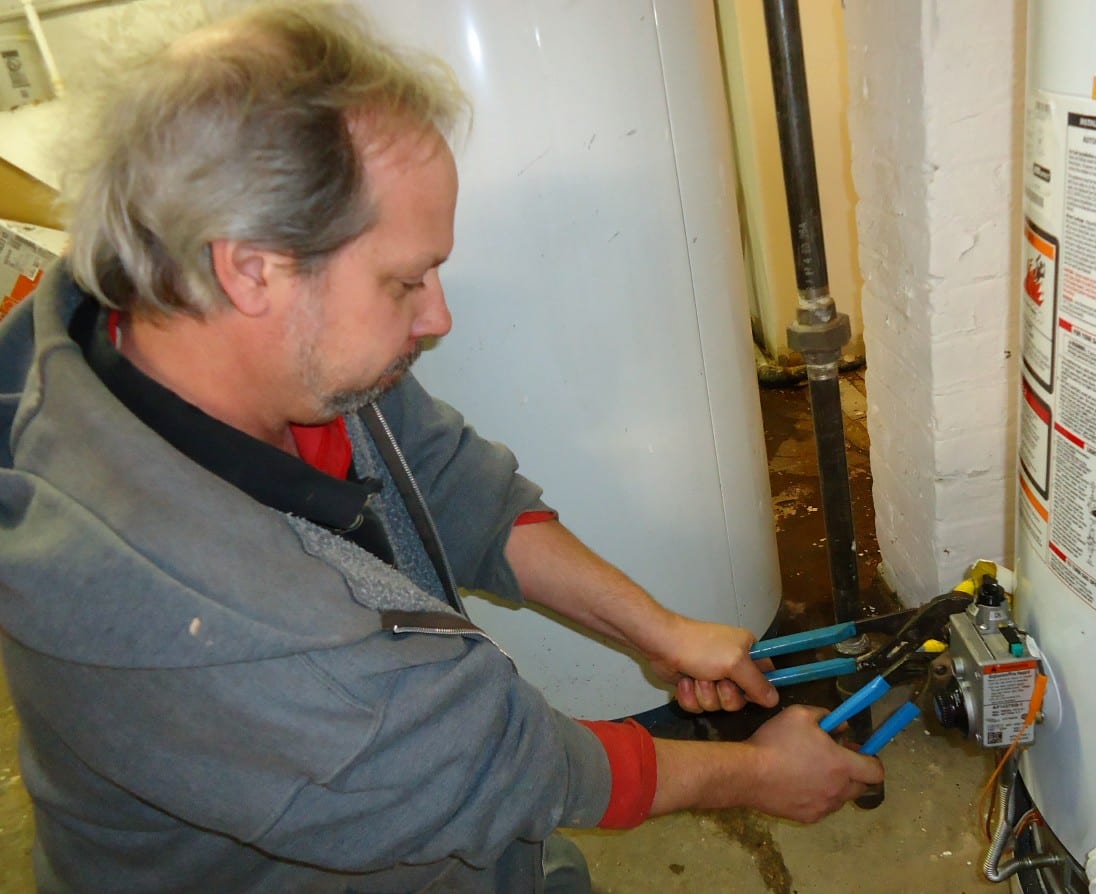 Two wrenches positioning a plumbing fitting